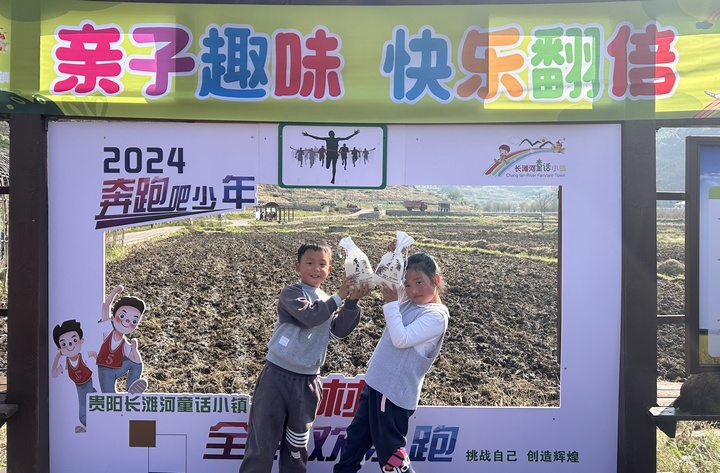 孩子們捧著贏得的農作物很開心。