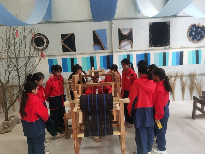 圖為組織學生開展布依紡織特色課程現場教學。