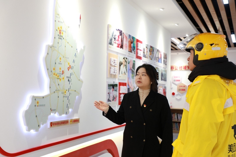 王涵向外賣小哥介紹轄區“小蜜蜂驛站”的分布情況