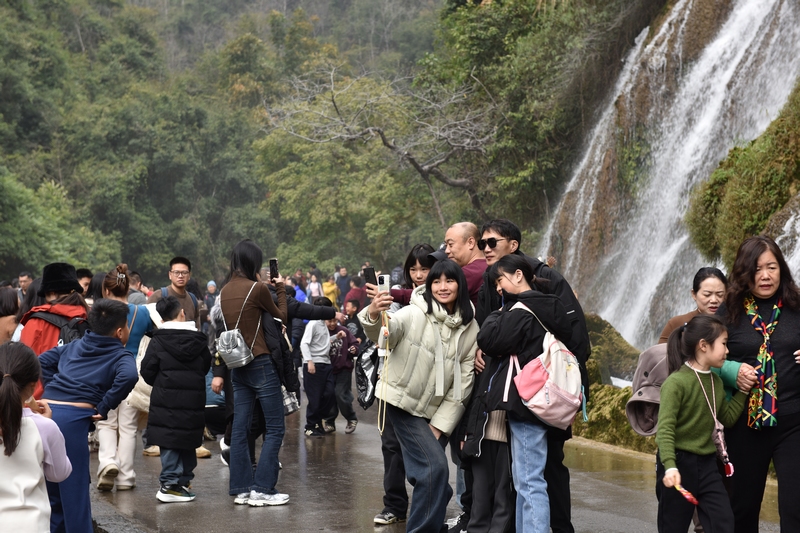 拉雅瀑布前游客打卡拍照留念。