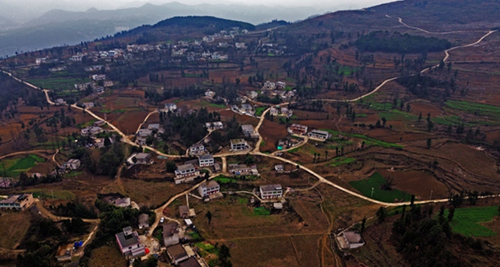 航拍貴州省黔西市鐵石苗族彝族鄉鐵盔山村的機耕道與村莊、山巒、田地構成一幅生機盎然的田園畫卷。  熊軍萬攝