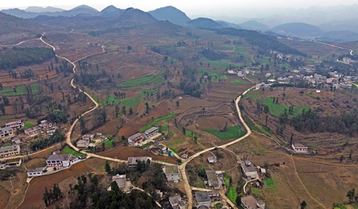 航拍貴州省黔西市鐵石苗族彝族鄉鐵盔山村的機耕道與村莊、山巒、田地構成一幅生機盎然的田園畫卷。  熊軍萬攝