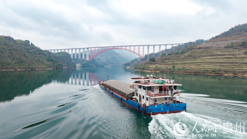 在烏江上航行的航電657號貨船與德余烏江特大橋同框。人民網記者 涂敏攝