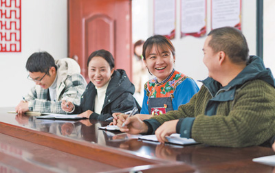 盧丹（右二）在致富村村委會和同事交流工作。