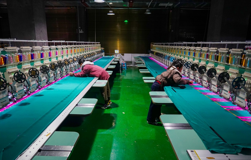 在貴州省從江縣美娥社區一家民族刺繡企業生產車間，工人在用數控機床生產刺繡產品。