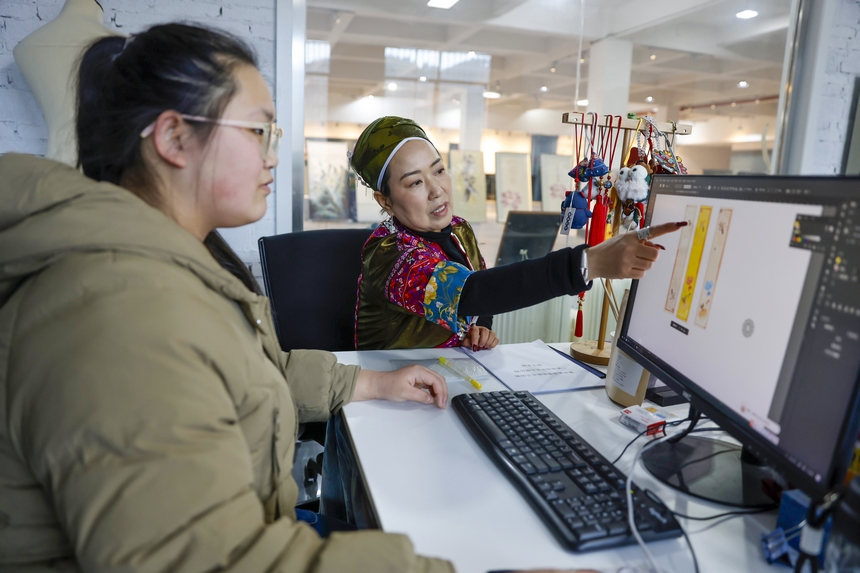 龍祿穎（右）與公司設計師討論新產品設計方案。