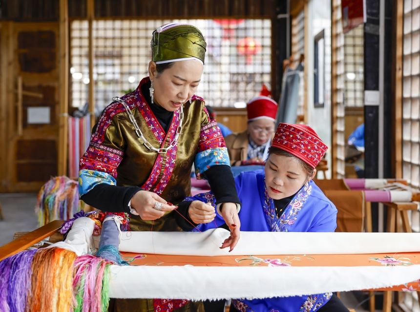 龍祿穎（左）在手工刺繡車間指導公司員工刺繡。