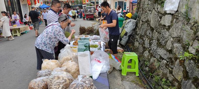 游客在鄉村集市購買土特產。桐梓縣融媒體中心供圖
