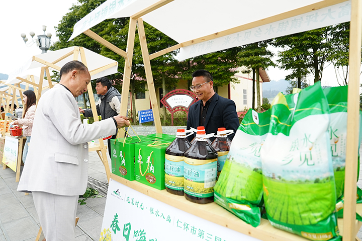 6、景區里設置“銀水集市”游客們前來咨詢購買農特產品。