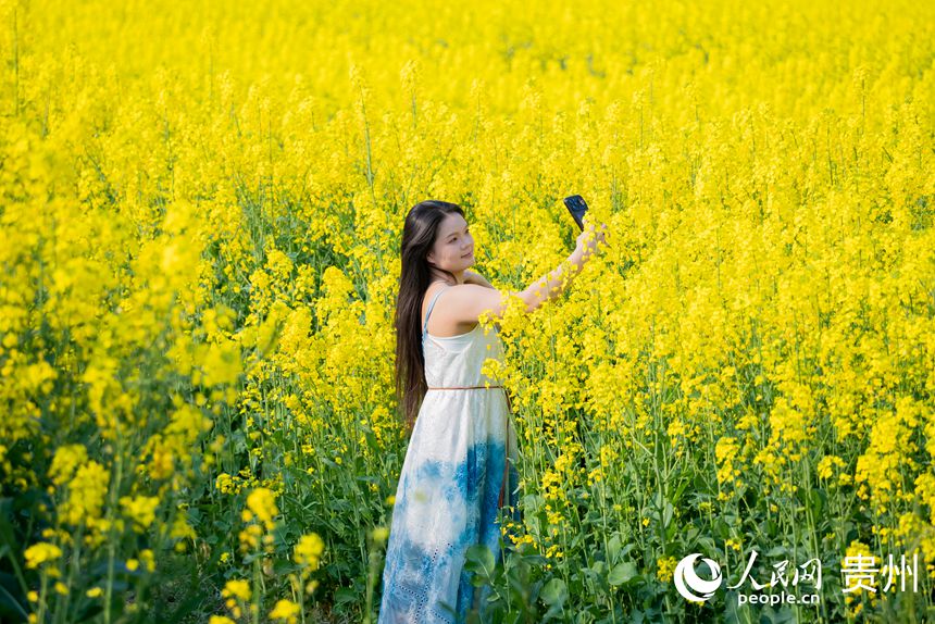 游客在油菜花田中賞花拍照。人民網記者 涂敏攝