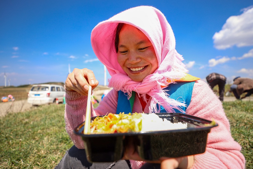 務工群眾在威寧自治縣雪山鎮大發村畫眉梁子馬鈴薯種植基地吃午餐。