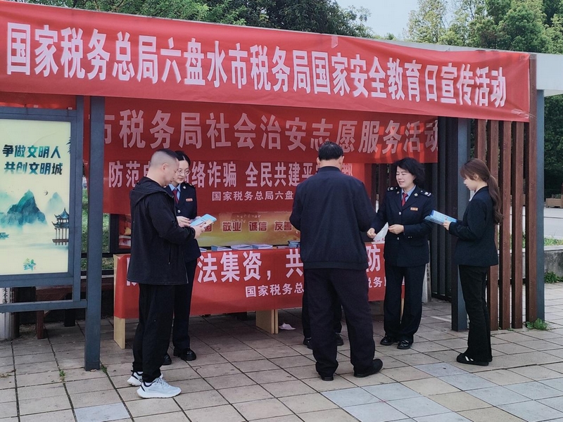 稅務人員為群眾發放并解讀宣傳手冊。梁敏攝