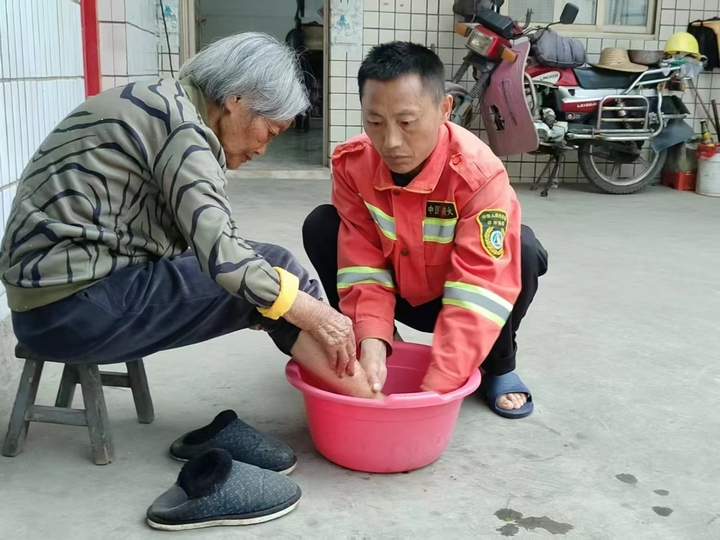 馮再華為母親洗腳。王蕓 攝.jpg