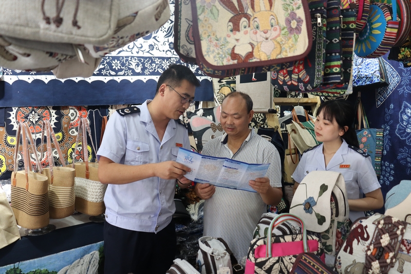 安順市鎮寧縣稅務局干部走進景區紀念品店為納稅人介紹最新稅費優惠政策。舒開培攝