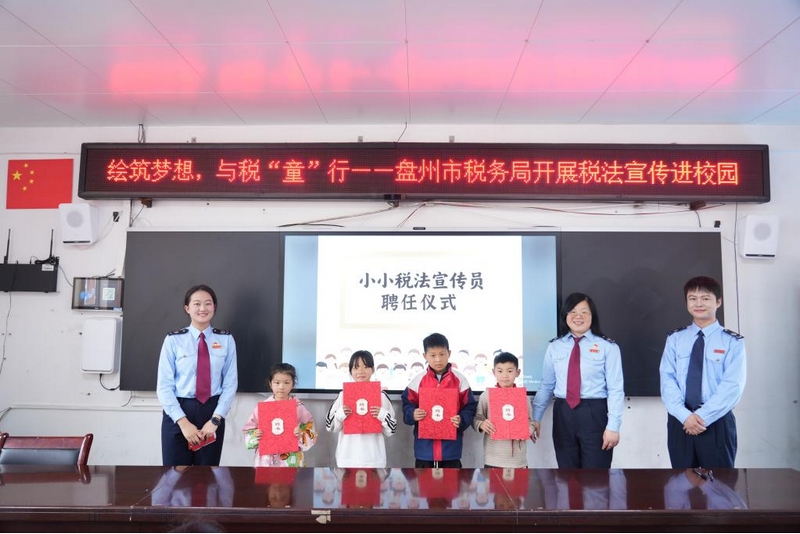 稅務干部為同學們頒發“小小稅法宣傳員”聘書。李琪攝