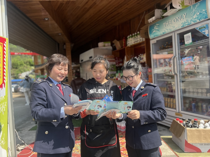 丹寨縣稅務局稅務干部向景區商戶開展稅收普法，引導其合規經營。吳珊珊攝