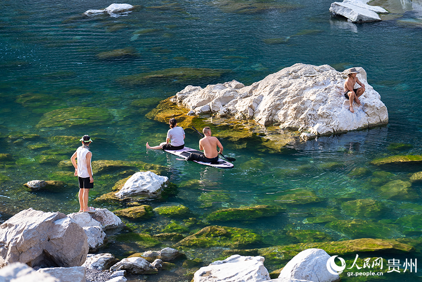 游客在清澈的河水中感受自然的樂趣。人民網記者 涂敏攝