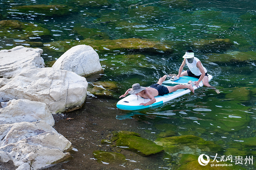 游客在清澈的河水中感受自然的樂趣。人民網記者 涂敏攝