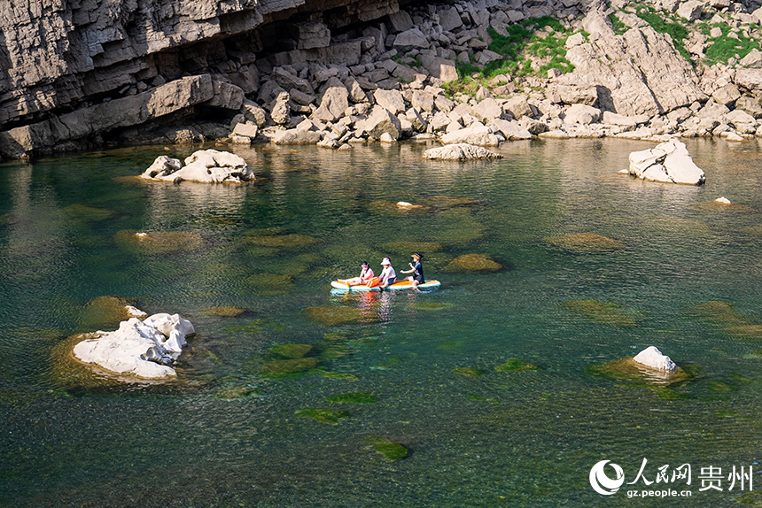 游客在清澈的河水中感受自然的樂趣。人民網記者 涂敏攝