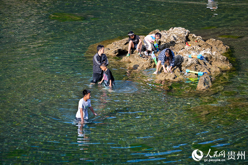 游客在淺灘處戲水嬉戲。人民網記者 涂敏攝
