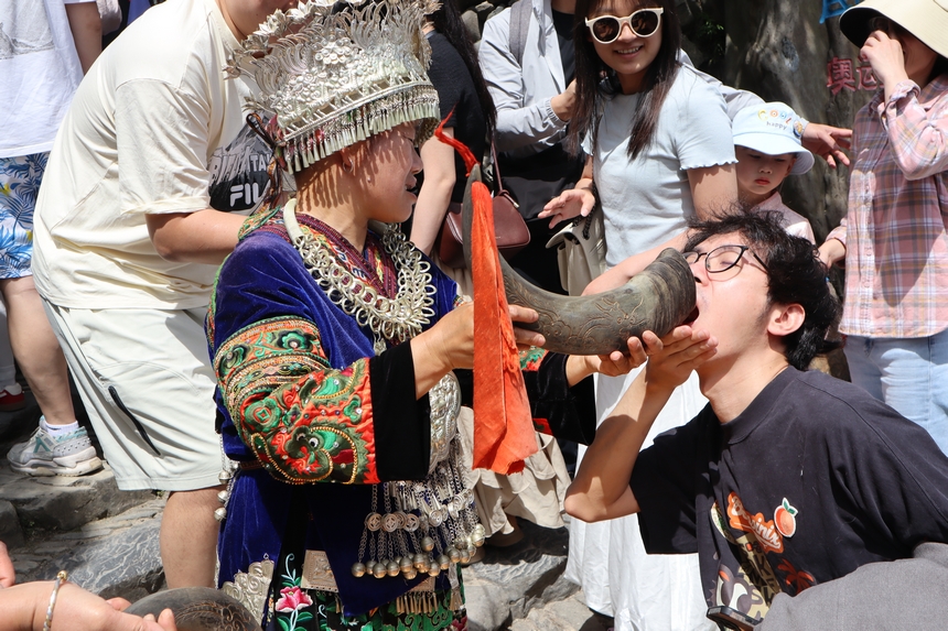 游客在郎德苗寨體驗攔門酒。