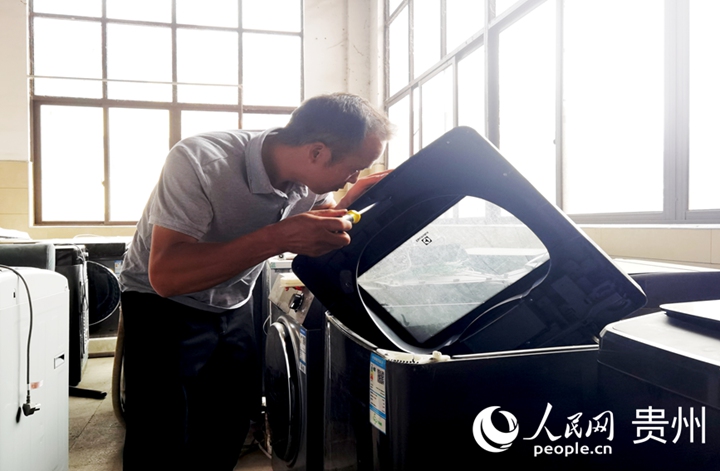 黎以明正在檢修剛回收來的洗衣機。人民網記者 王秀芳攝