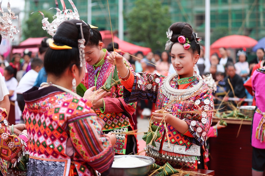 2025年5月29日，在貴州省丹寨縣金泉街道，身著傳統服飾的搬遷群眾在參加包粽子比賽。