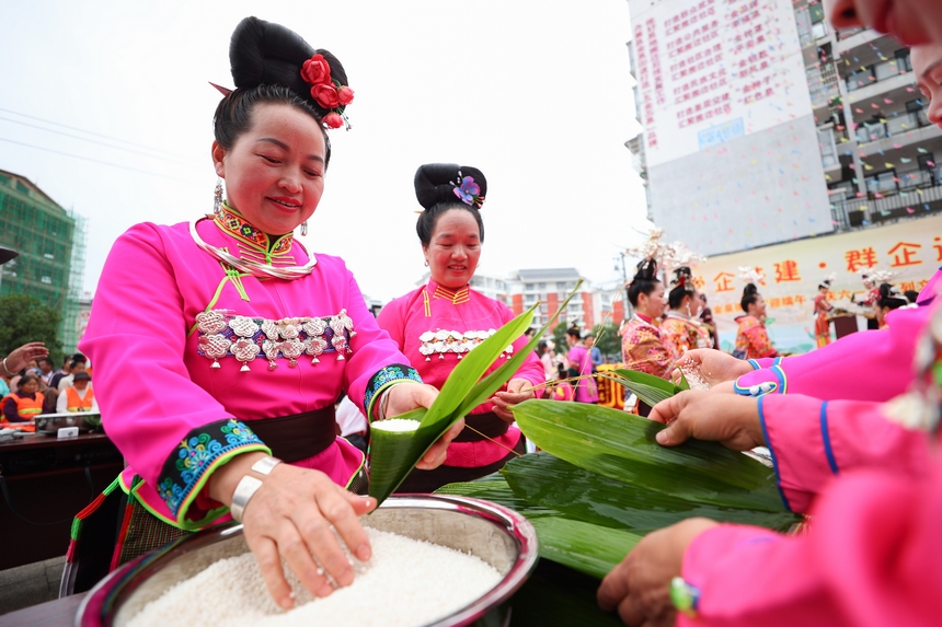 2025年5月29日，在貴州省丹寨縣金泉街道，身著傳統服飾的搬遷群眾在參加包粽子比賽。