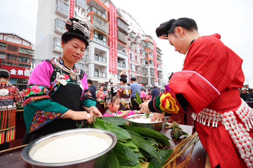 2025年5月29日，在貴州省丹寨縣金泉街道，身著傳統服飾的搬遷群眾在參加包粽子比賽。