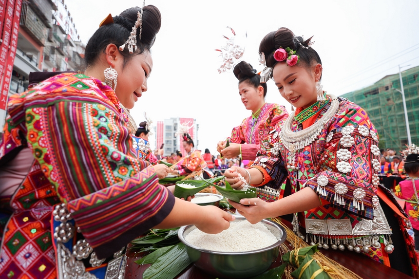 2025年5月29日，在貴州省丹寨縣金泉街道，身著傳統服飾的搬遷群眾在參加包粽子比賽。
