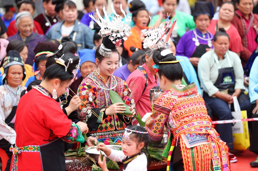 2025年5月29日，在貴州省丹寨縣金泉街道，身著傳統服飾的搬遷群眾在參加包粽子比賽。