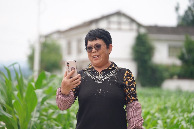 淹壩村村民鐘德容正與遠在浙江務工的兒子通視頻。吳艷禹攝