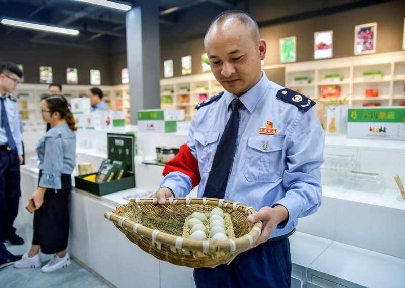 圖為國家稅務總局畢節高新區稅務分局派駐赫章雙坪鄉的第一書記周榮正為村民售賣雞蛋。村委會供圖