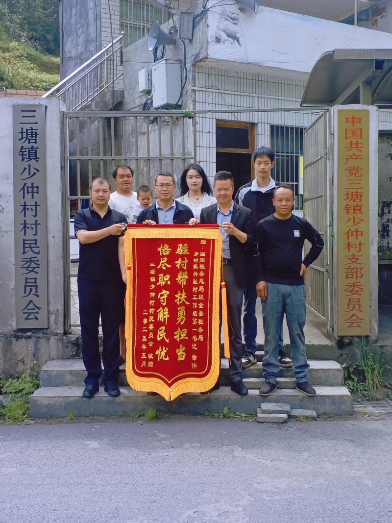 村委會為稅務干部送上錦旗并合影。村委會供圖