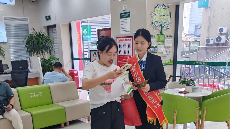 工作人員向網點等候客戶宣傳“陽光信貸”。