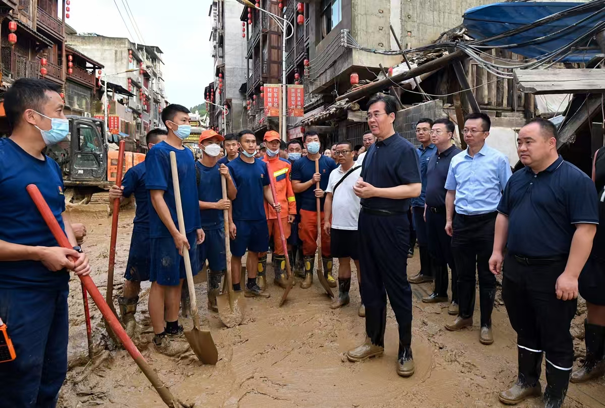 圖為李炳軍在榕江縣古州鎮場壩社區親切看望慰問一線搶險救援人員。