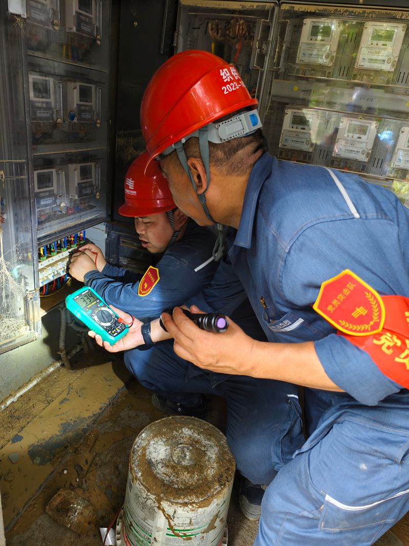 南方電網貴州畢節供電局黨員突擊隊隊員使用萬用表檢查低壓線路是否具備送電條件。羅根攝