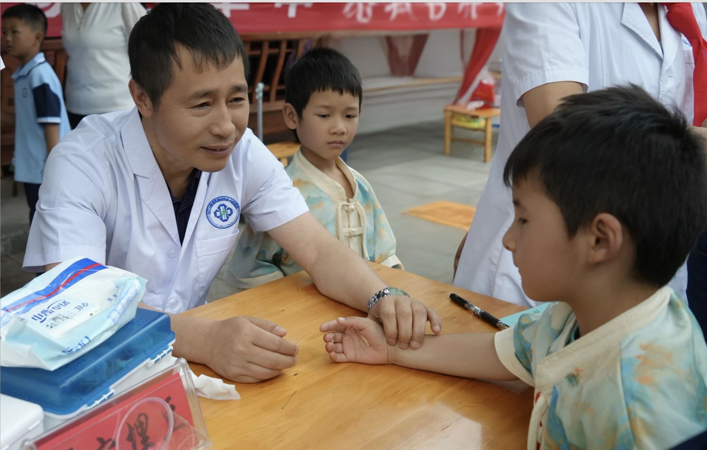 印江自治縣中醫醫院醫務人員為小學生把脈.jpg
