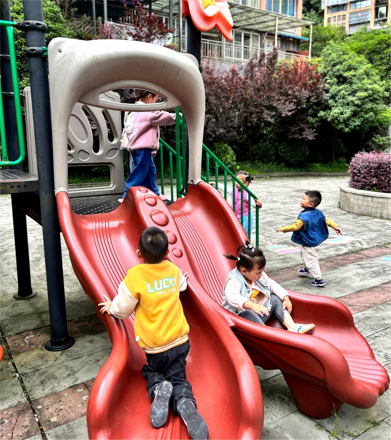 兒童樂園里，滑梯笑聲和樹蔭里的閑談聲纏在一起。王燁攝