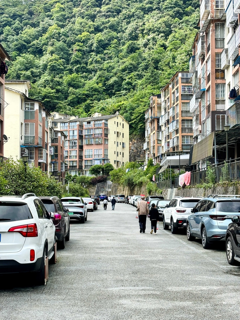 步入小區，步道兩側整齊地停滿了渝字開頭的車輛。老人牽著孫輩散步。王燁攝