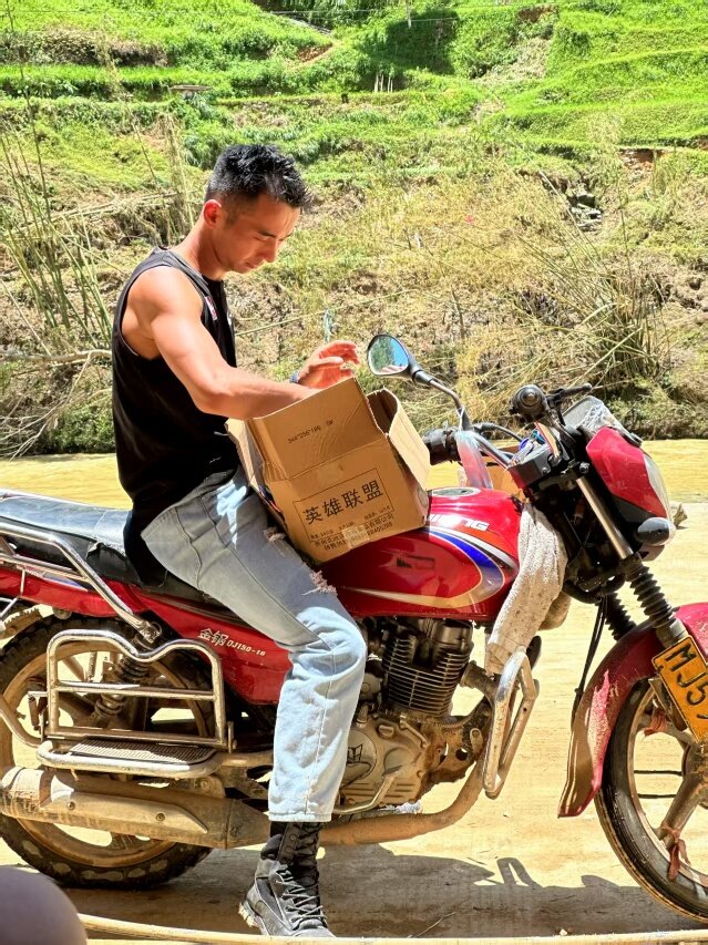 平永橋騎著摩托車運送救災物資。