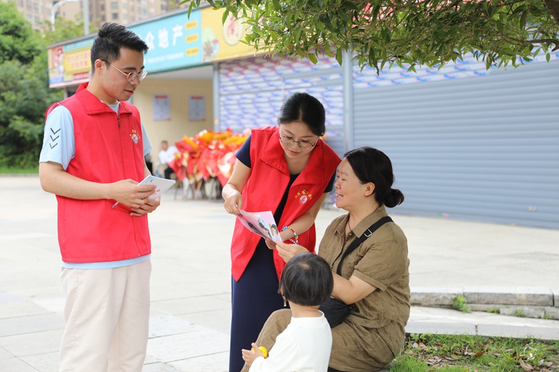 南山社區網格員正在給市民宣傳有關政策。