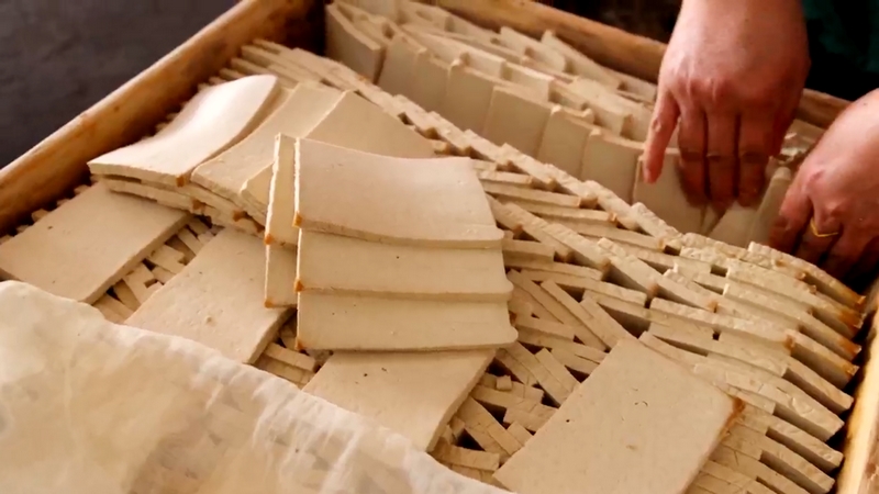 制作好的豆腐切成小片放入木框進行天然發酵。