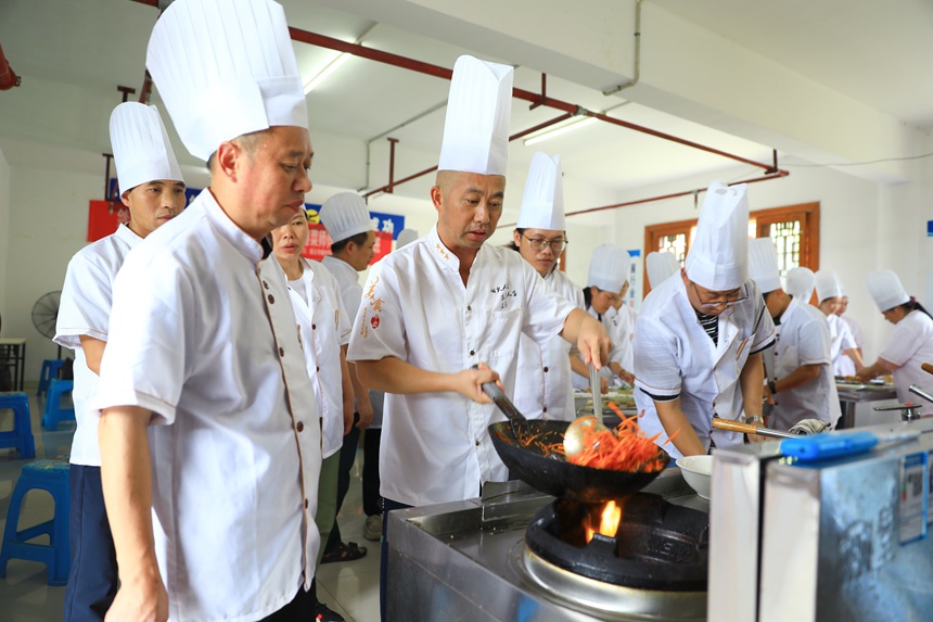 中式烹調師（粵菜師傅）老師在教學顛勺技巧。