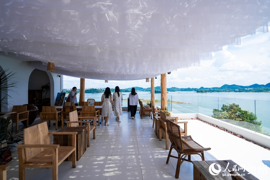 湖邊的民宿里，游客在觀景陽臺上觀光拍照。人民網記者 涂敏攝