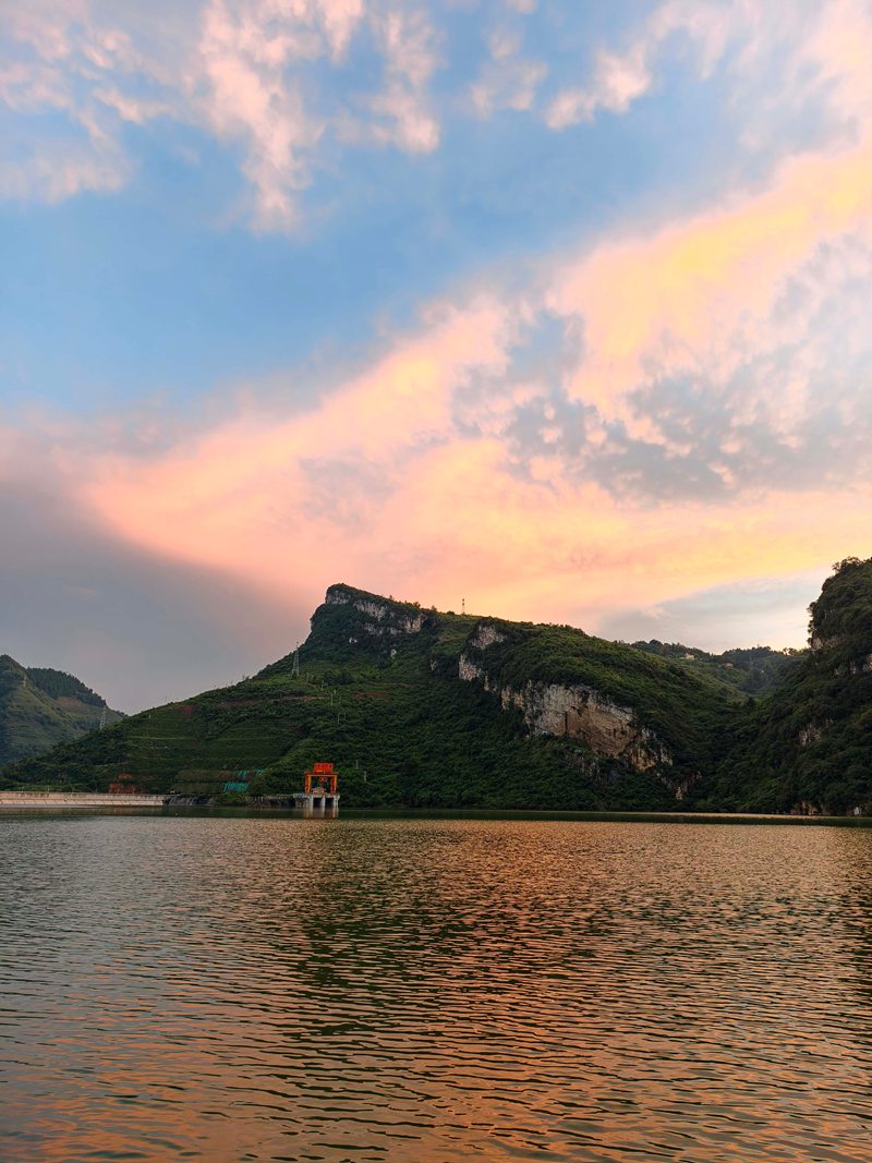 雨后的夾巖水庫空氣清新,落日余暉穿透云層,為天際染上橙紅、鎏金與淡紫的漸變色。張榮攝