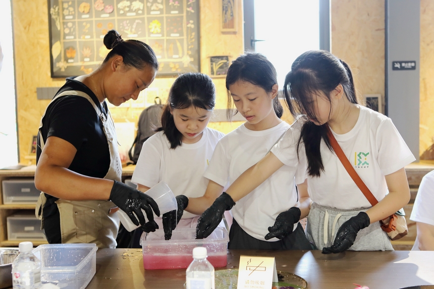 來自上海的孩子在工作人員的帶領下體驗制作火龍果冰涼粉。