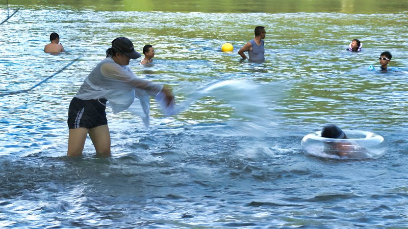 家長和孩子在水中戲水。