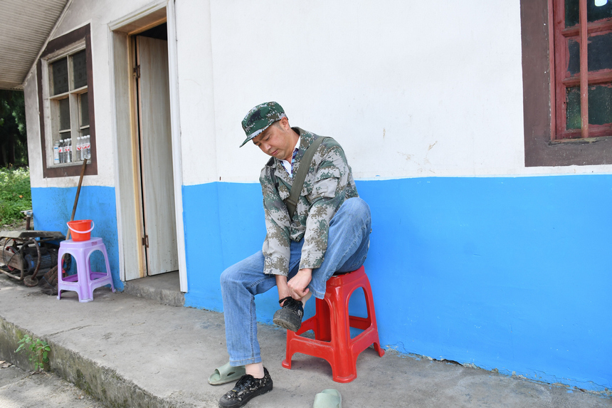 姚克禮換上膠鞋準備巡林。