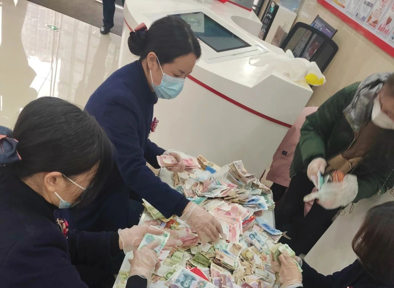 貴州銀行工作人員為顧客清點零鈔。